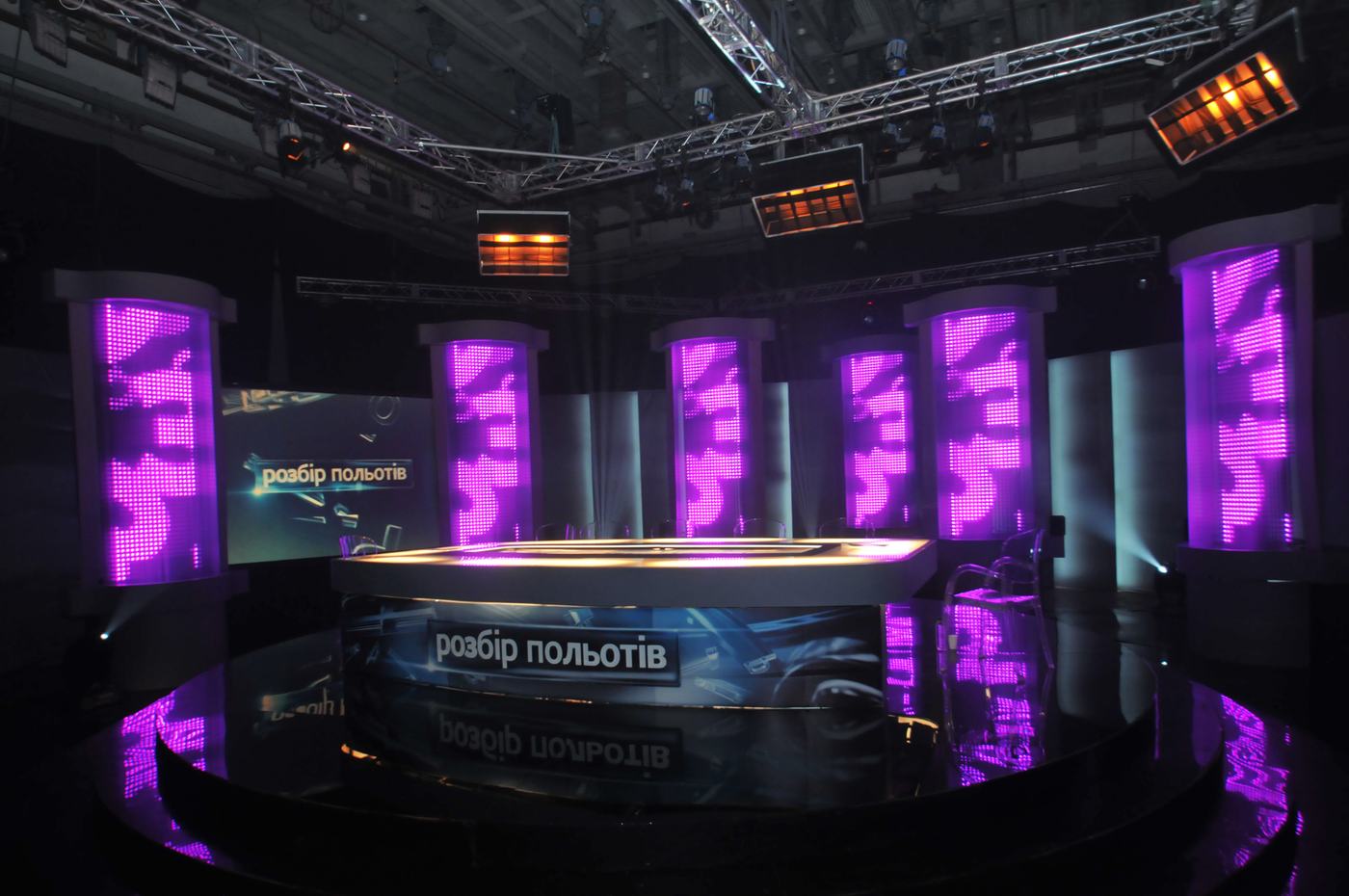 Violet TRUE dvLED columns ringing a round analysis desk in a dark studio