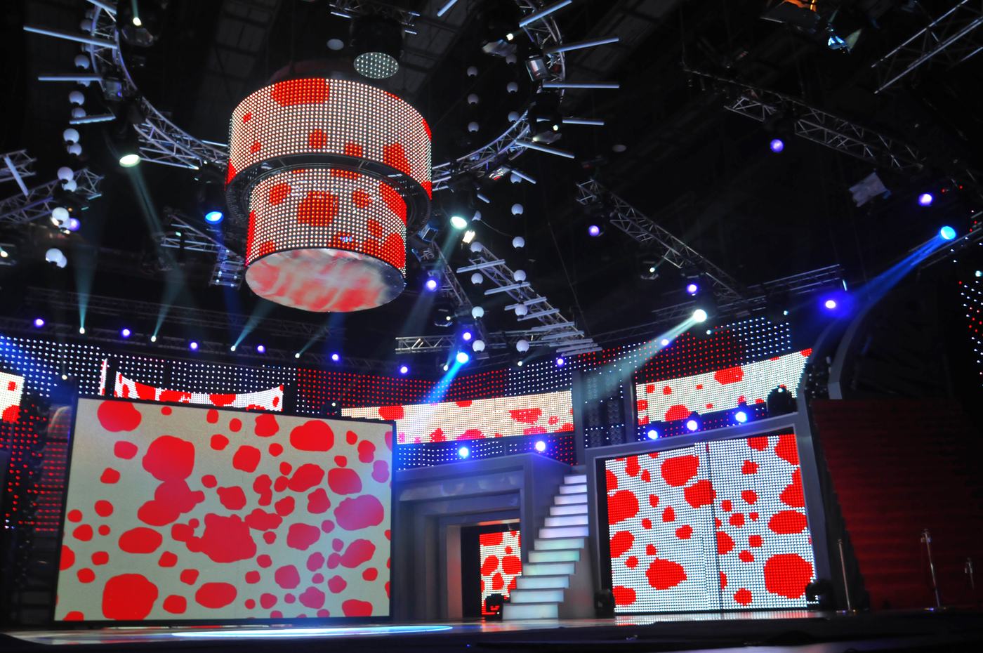 Suspended TRUE dvLED drum above a staircase set with red poppy graphics on white walls