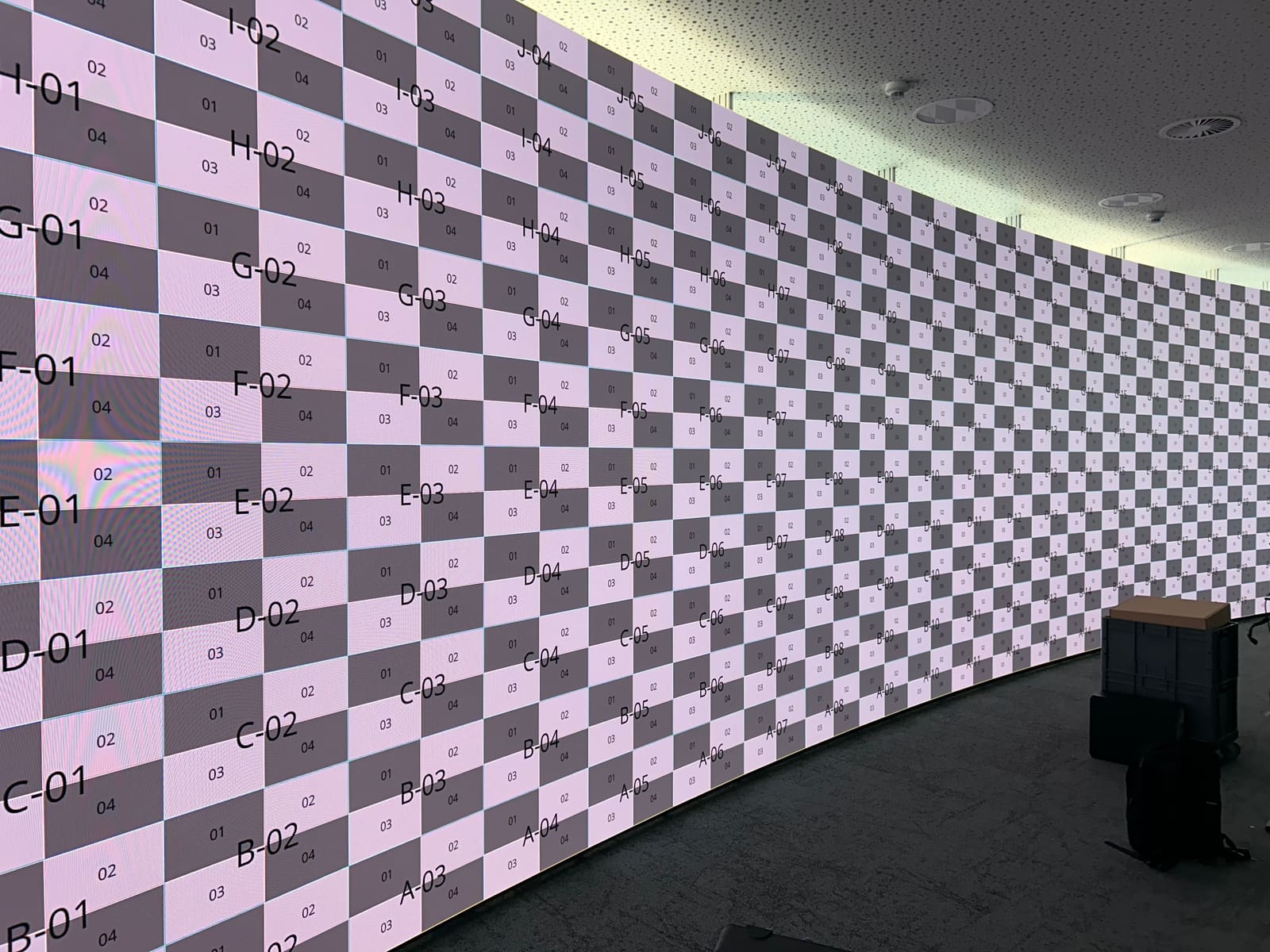 Long curved TRUE dvLED wall running a checkerboard test pattern in an empty control room