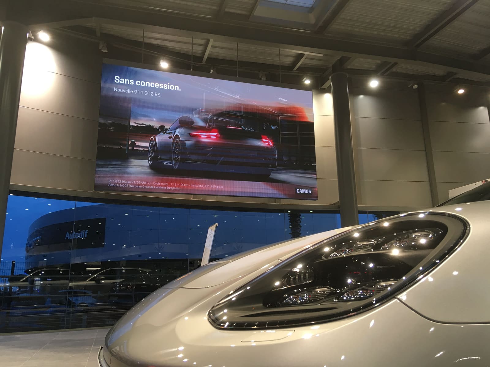 TRUE dvLED wall in a Porsche showroom at dusk with a car in the foreground