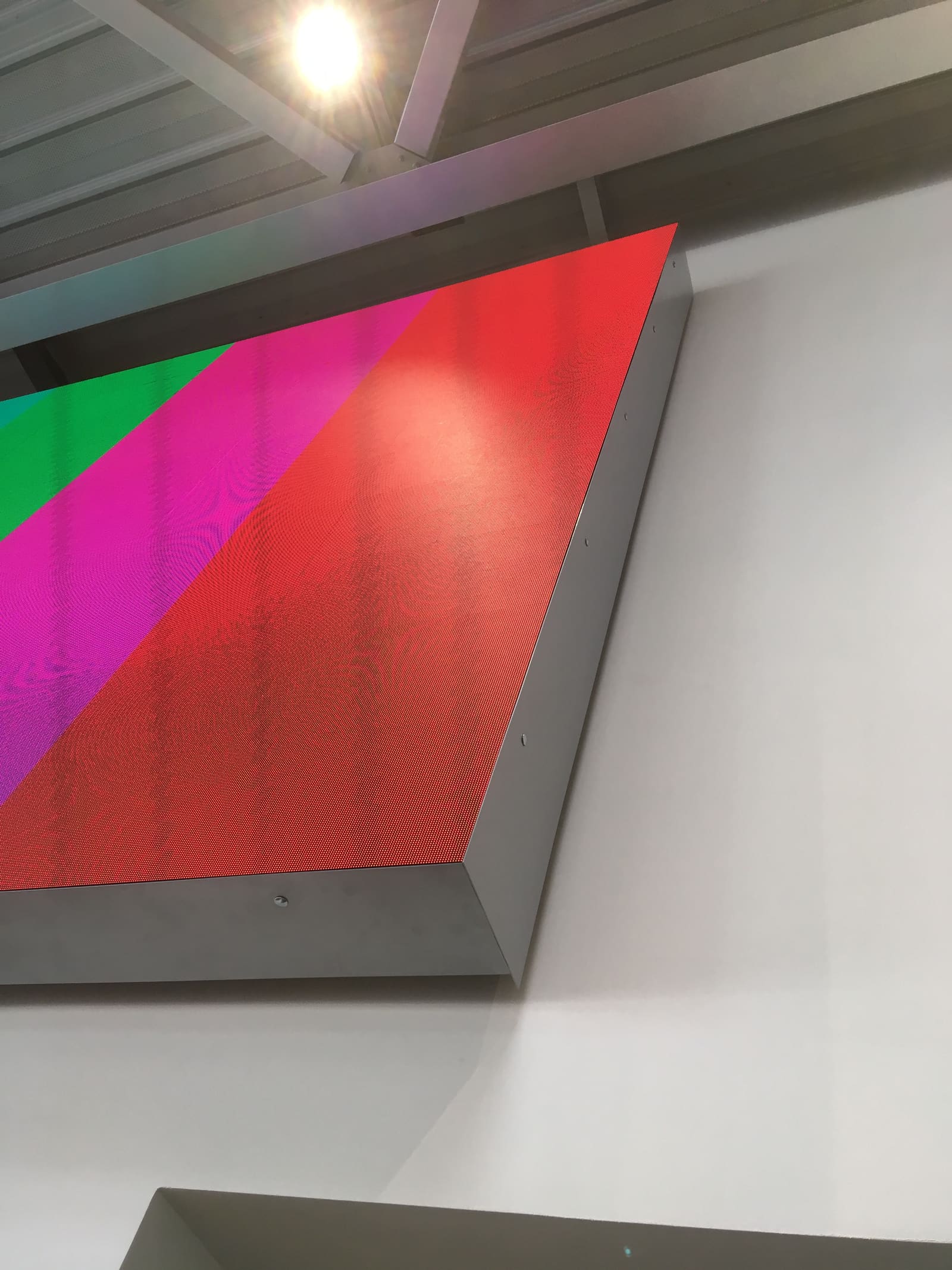 Close view of a TRUE dvLED panel edge and frame with saturated color bars running