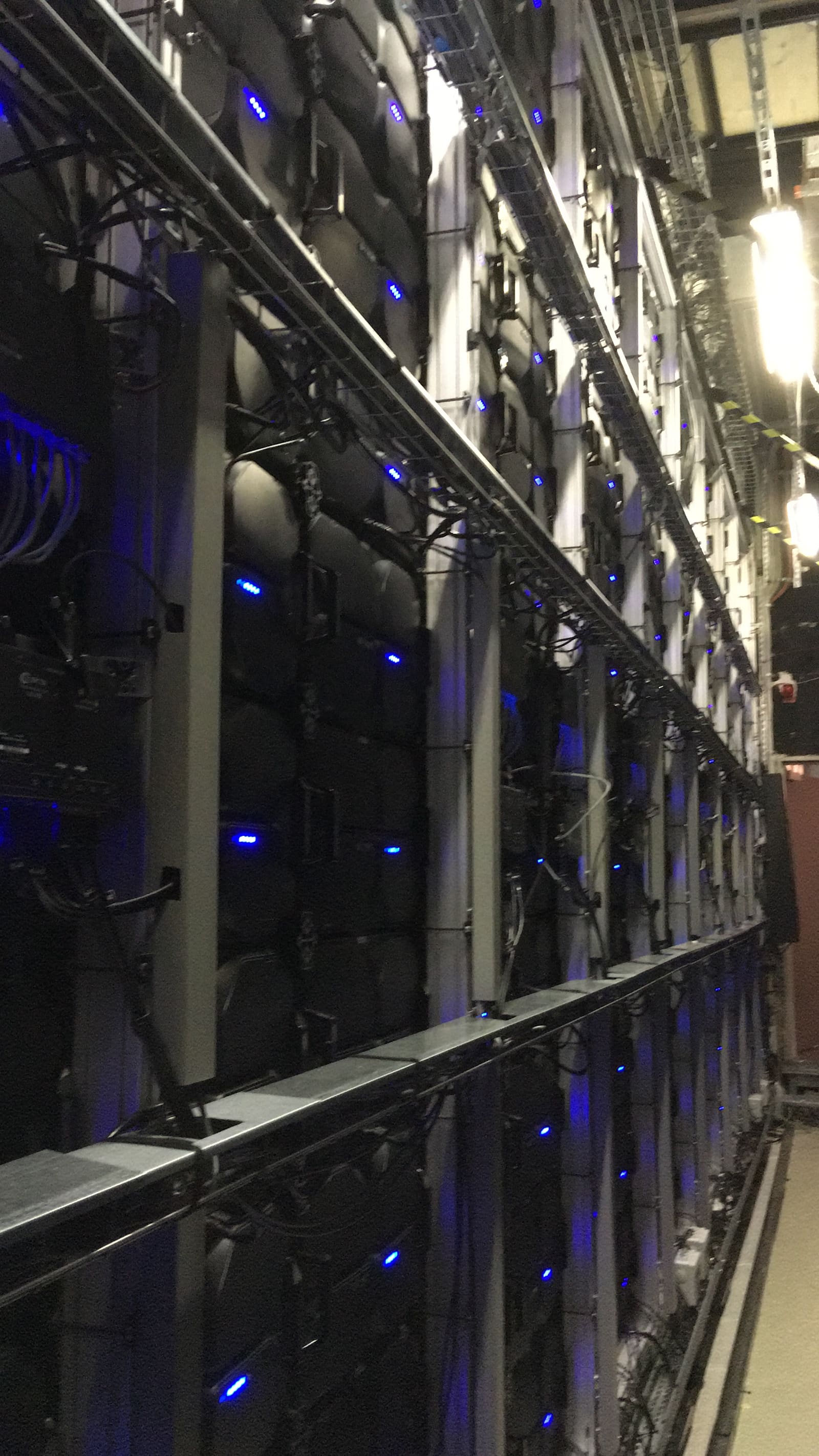 Rows of blue status LEDs on the rear of TRUE dvLED cabinets in a dark room