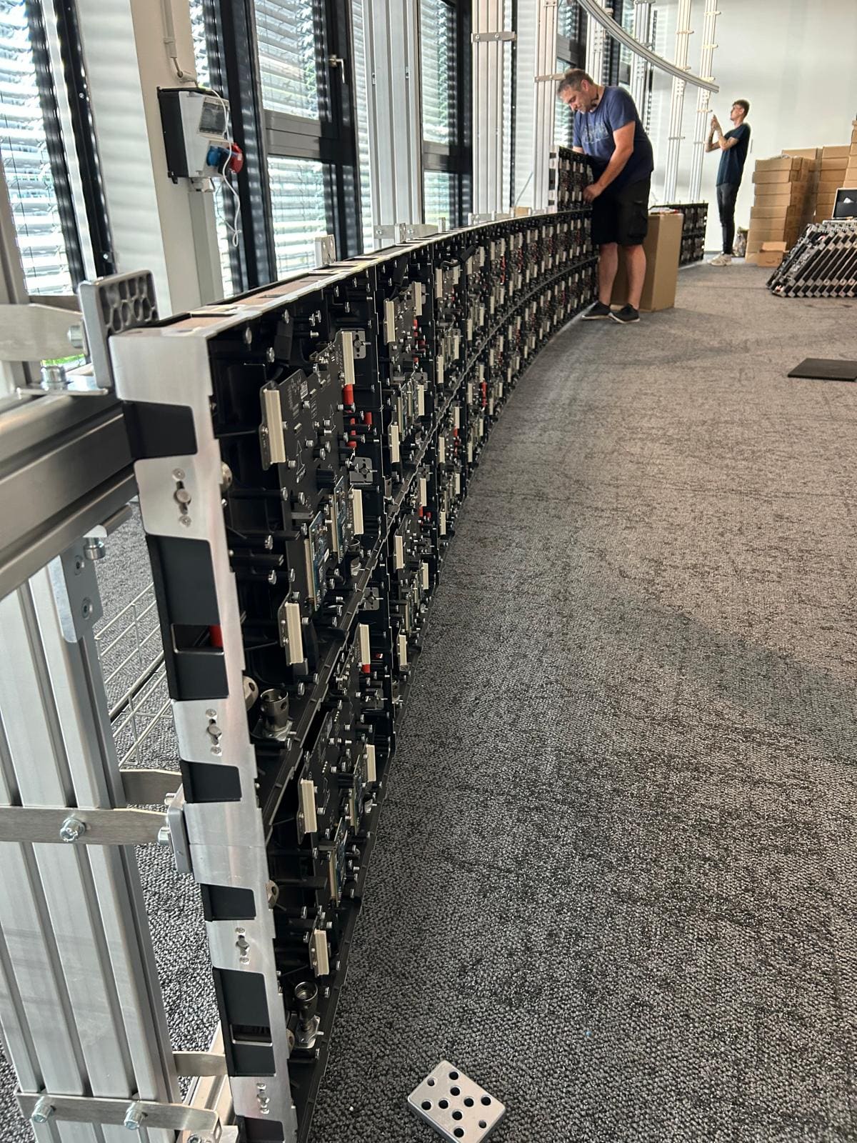 Technicians fitting panels on the rear of a curved TRUE dvLED wall during installation