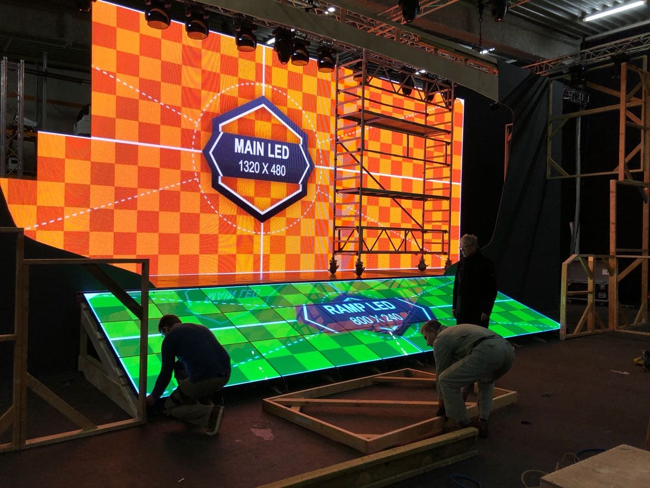 Stage build with a main TRUE dvLED wall and a dvLED ramp floor, crew at work