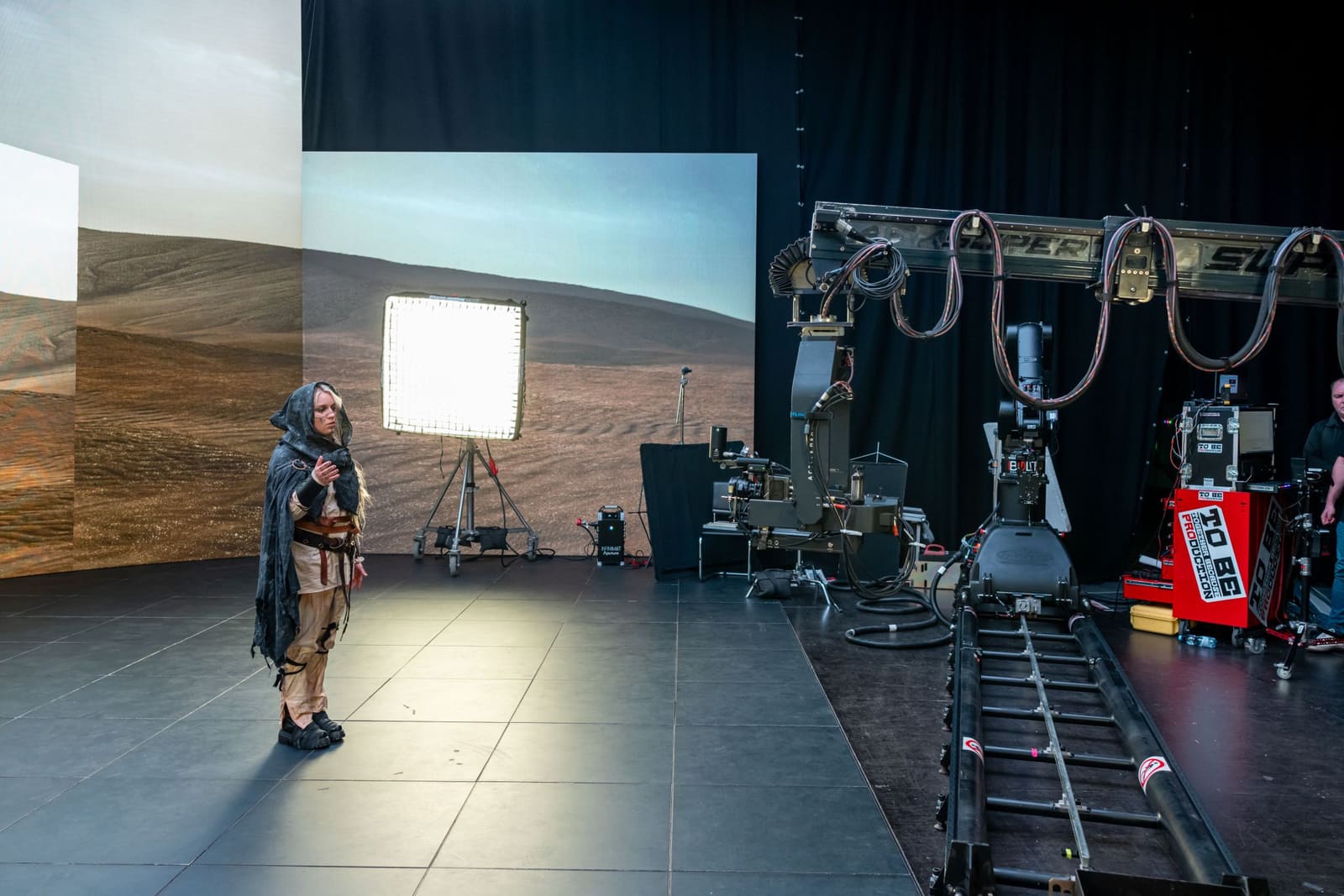 Performer on a TRUE dvLED stage with dolly track and a motion control camera arm
