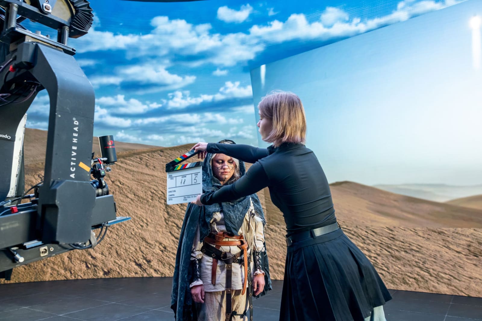 Clapperboard held before a costumed performer on a TRUE dvLED volume showing sky
