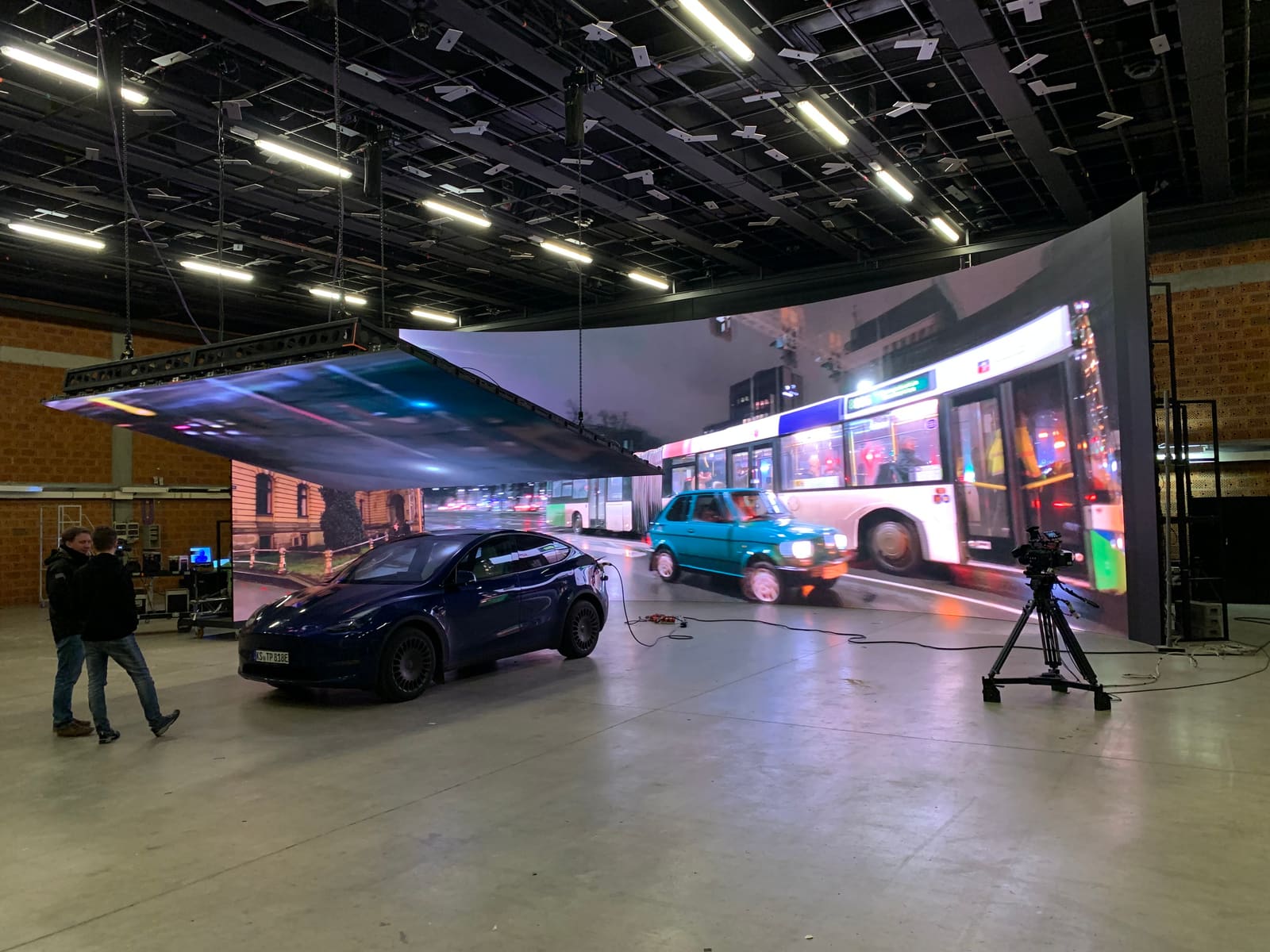 LED volume with ceiling panels around a car on set, cinema camera in position
