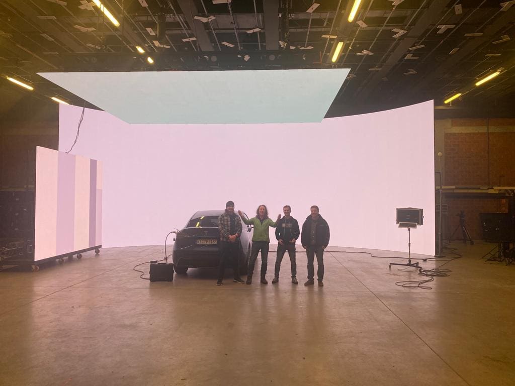 TRUE dvLED volume with wall and ceiling panels around a car, crew standing in shot