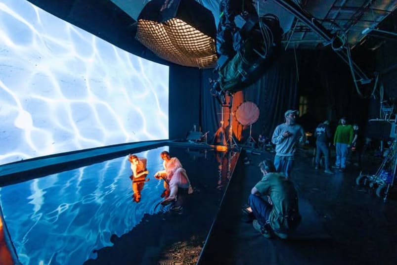 Curved TRUE dvLED volume around a water tank with camera rig and crew