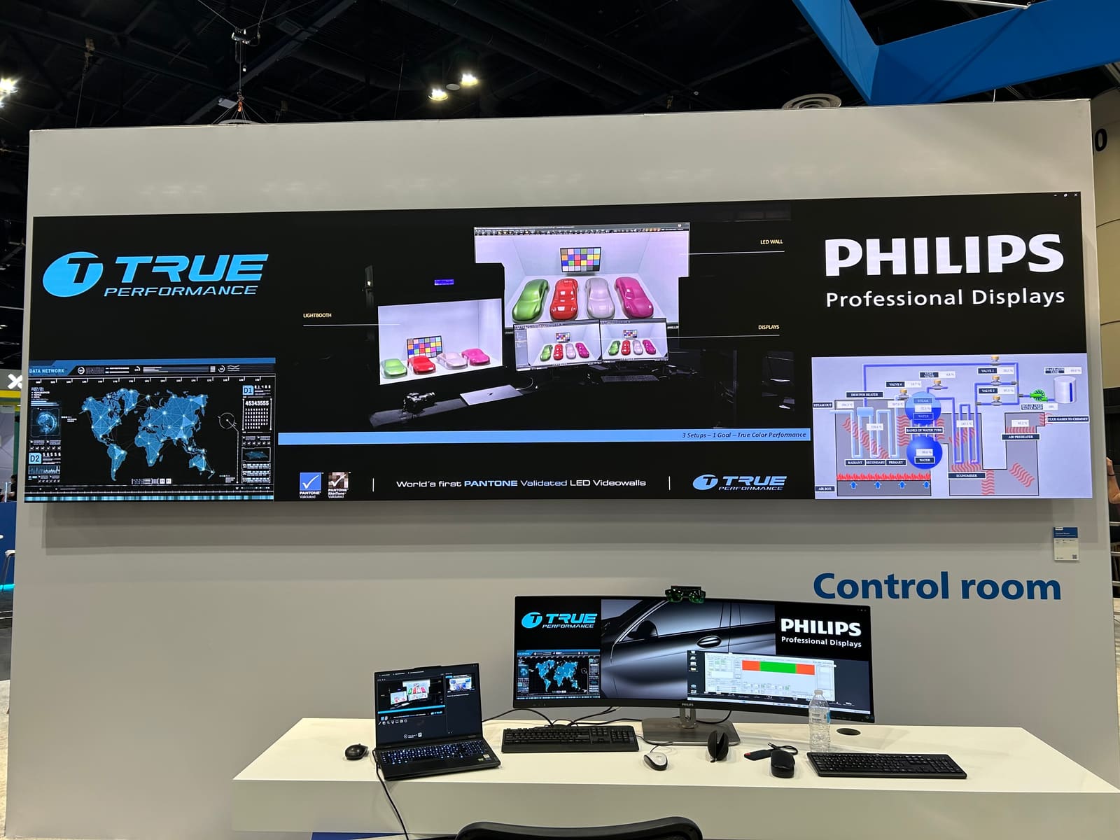 Trade show stand with a wide TRUE dvLED wall showing car color calibration and control room graphics