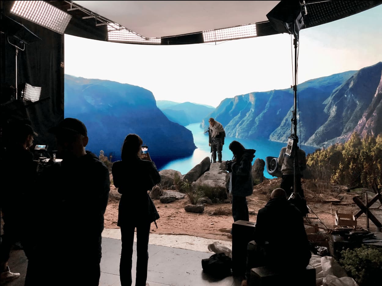 Film crew silhouetted in front of a TRUE dvLED volume displaying a blue fjord landscape